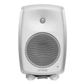 White studio monitor speaker with front metal speaker grilles and a green indicator light lit.