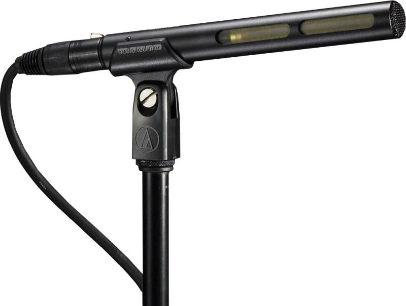 Black shotgun microphone mounted on a microphone stand with cable and clip attached.