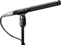 Black shotgun microphone on a stand with a connected cable and mount tightening knob.