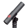Gray cylindrical microphone with red diamond logo mounted on a black adjustable stand clip.
