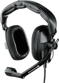 Black over-ear headphones with large cushioned ear pads and an attached boom microphone with a rotary knob.