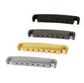 Four metal guitar tailpieces in different finishes arranged on a white background.