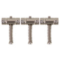 Three silver metal saddles with springs and adjustment screws arranged side by side on a white background.