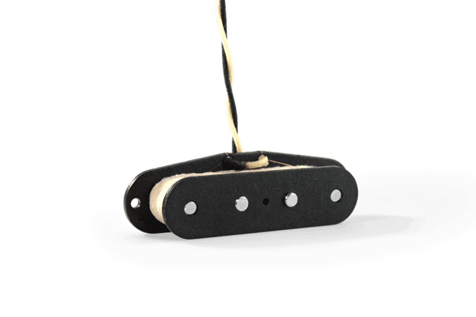 Black electric guitar pickup with four metal pole pieces and cloth-covered twisted wire leads.