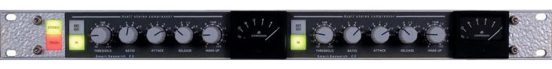 Front panel of a black dual stereo audio compressor with knobs, switches, and meters in a silver rack mount frame.