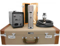 Studio microphone with power supply, audio cable, wooden box, and carrying case displayed on a surface.