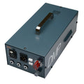 Dark teal rectangular audio device with handle, multiple audio connectors and control knobs on front panel.