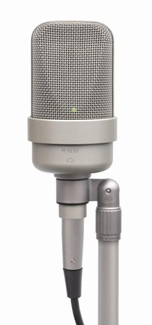 Silver studio microphone with mesh grille and attached cable on a stand mount