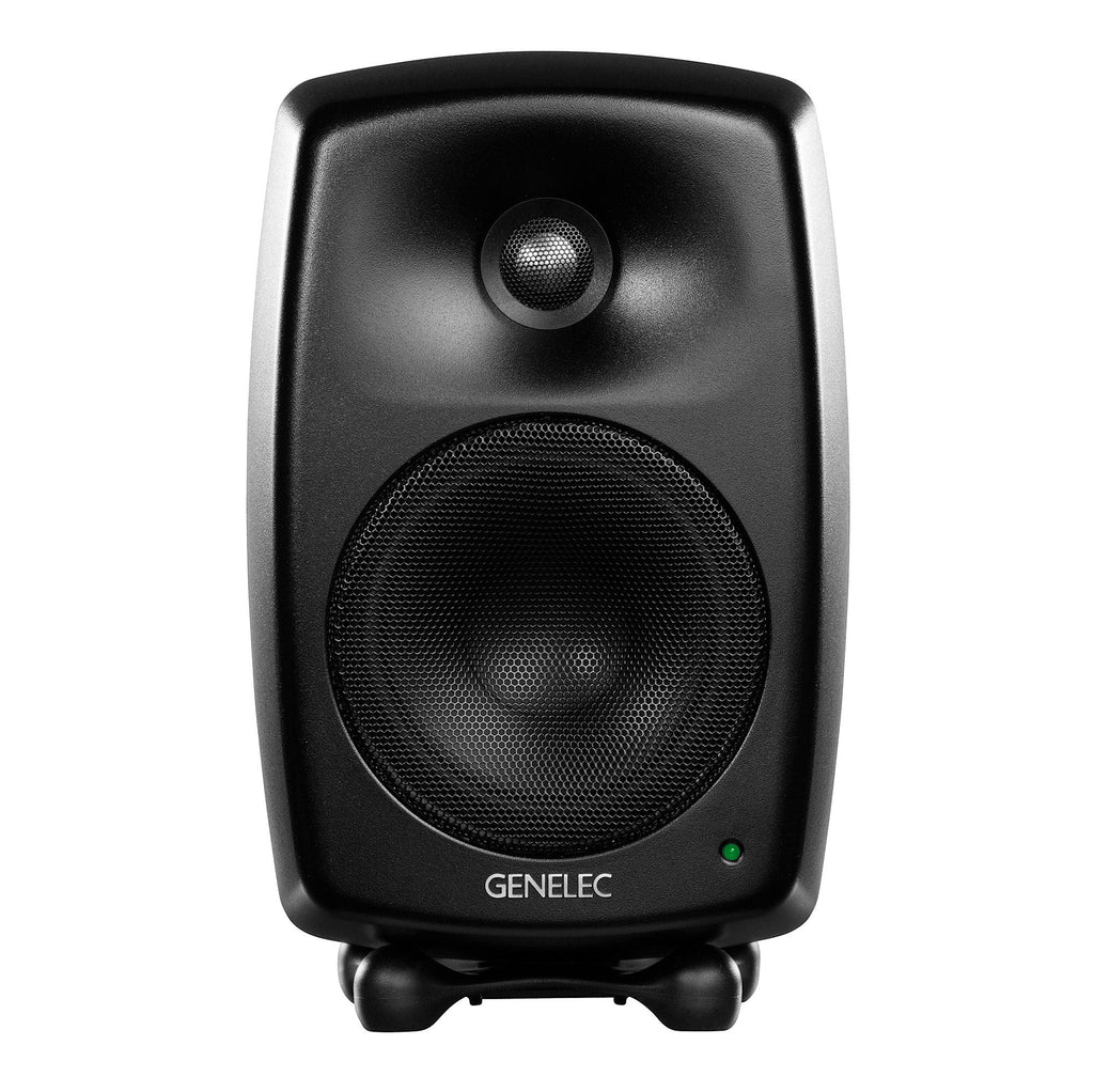 Front view of a black Genelec studio monitor speaker with a green LED light and protective mesh covers on drivers.