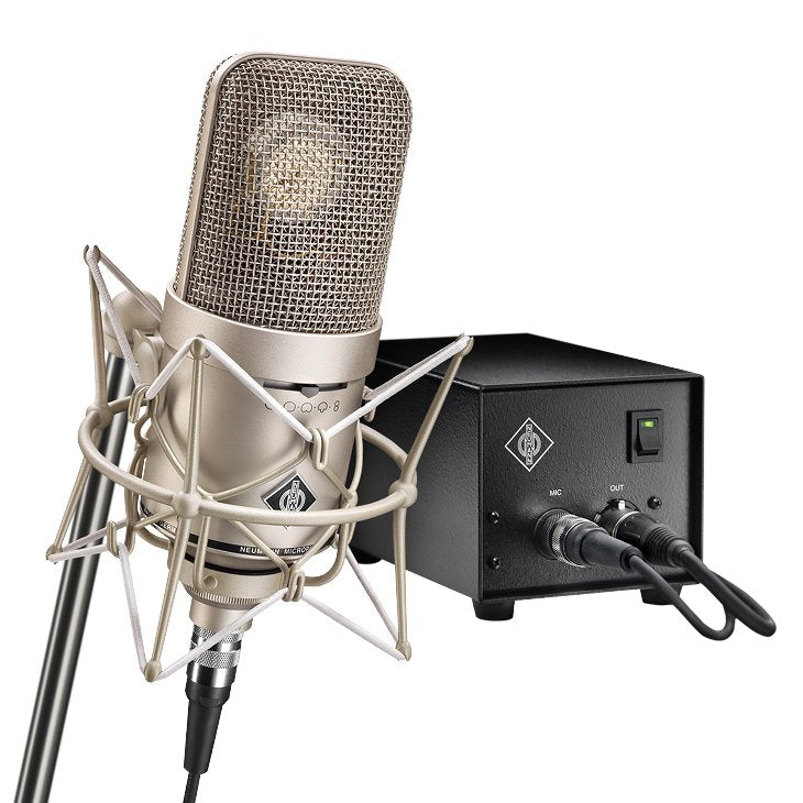 Silver studio microphone in shock mount connected to a black control box with cables and toggle switch