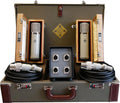 Open combination-locking flight case containing the TELEFUNKEN ELA M 251E Stereo Set: two cream-bodied tube condenser microphones with chrome grilles resting in open wooden boxes, a dual power supply with four XLR connectors in the center, and two coiled microphone cables, with the gold TELEFUNKEN diamond logo on the case lining.