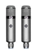 Matched pair of TELEFUNKEN U48 large-diaphragm tube condenser microphones, each a long cylindrical body with grille headbasket and red polar-pattern badge, shown with dual power supply and included accessories.