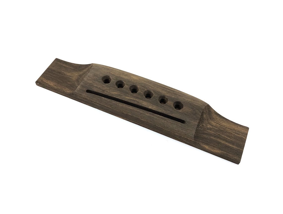 Dark brown wooden acoustic guitar bridge with six string holes and a slot in the center.