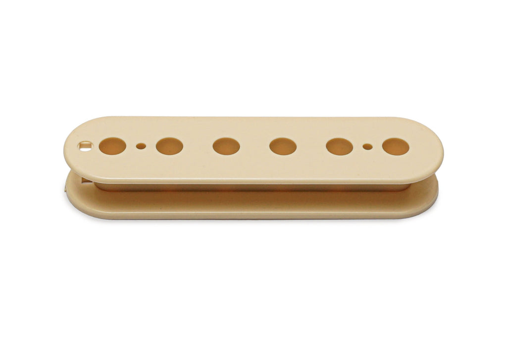 Cream-colored pickup bobbin with six circular holes for pole pieces, viewed from above.