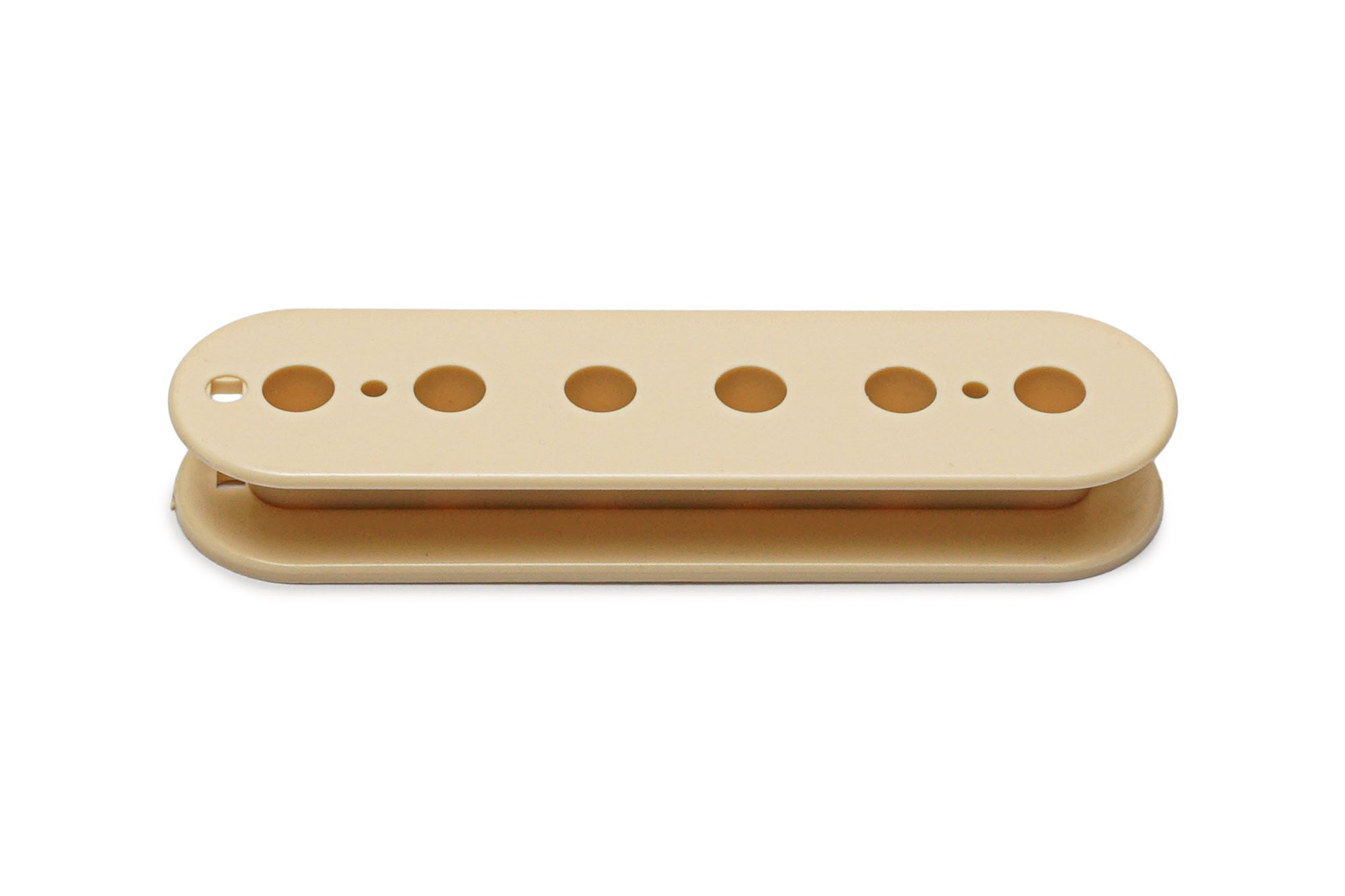 Cream-colored pickup bobbin with six circular holes for pole pieces, viewed from above.