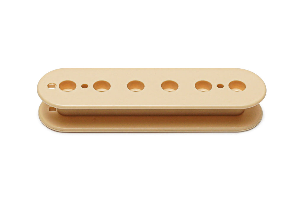 Cream-colored plastic pickup bobbin with seven holes, viewed from the side on a white background.