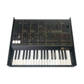 Black synthesizer keyboard with sliders, switches, and labeled sections on the control panel.