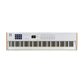White MIDI keyboard controller with 88 keys, pads, knobs, sliders, and a small display screen.