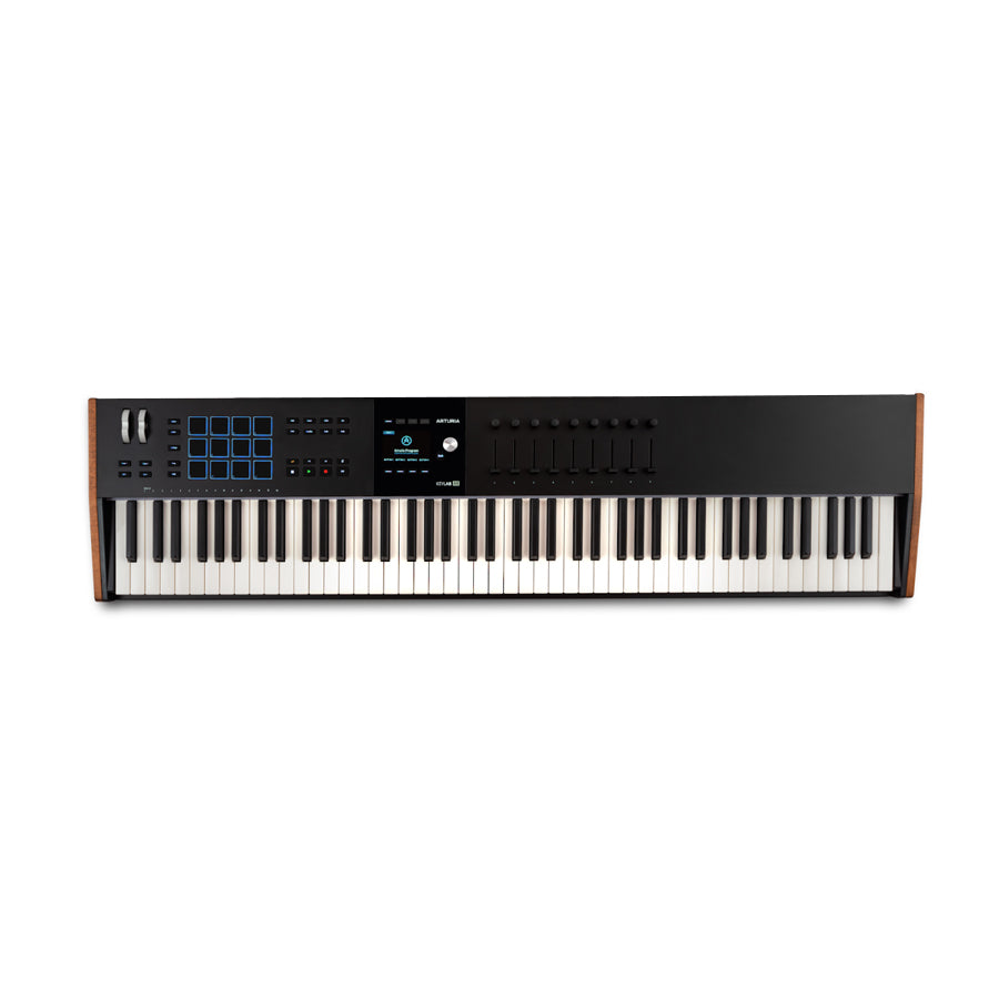 Black keyboard controller with 88 keys, blue-lit pads, multiple knobs and faders, and a small display screen.