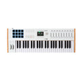 White MIDI keyboard controller with 49 keys, pads, knobs, sliders, and a color display on a white background.