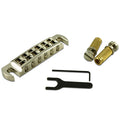 Silver wraparound guitar bridge with two gold threaded posts, a hex key, and a black adjustment tool on white background