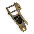 Gold-colored vibrato tailpiece with a lever and Bigsby patent label attached.