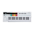 White MIDI keyboard controller with black and white keys, rotary knobs, buttons, and colorful labeled pads.