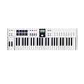 White MIDI keyboard controller with 49 keys, 8 black square pads, 9 faders, knobs, buttons, and a small display screen.