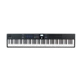 Black MIDI keyboard controller with 88 keys, control wheels, pads, knobs, faders, and buttons with small display in center.