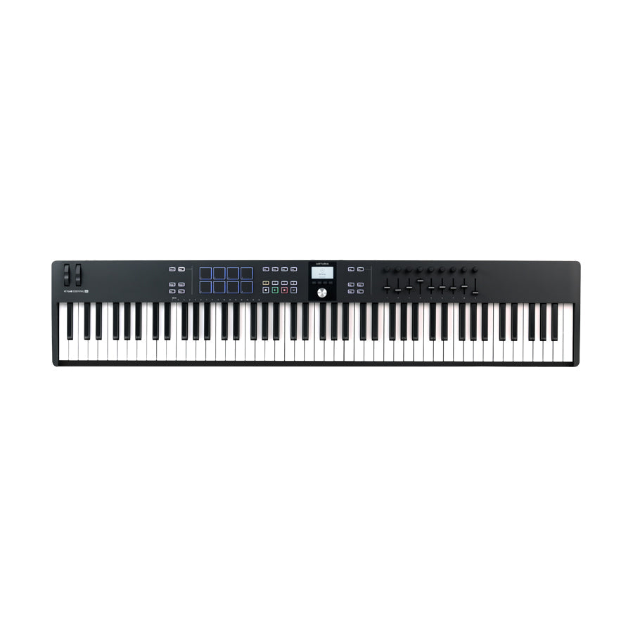 Black MIDI keyboard controller with 88 keys, control wheels, pads, knobs, faders, and buttons with small display in center.