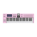 Pink MIDI keyboard controller with 49 keys, pads, faders, knobs, wheels, and a small display screen.