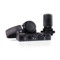 Black audio interface with two combo input jacks, headphones, and a microphone with shock mount on a white background.