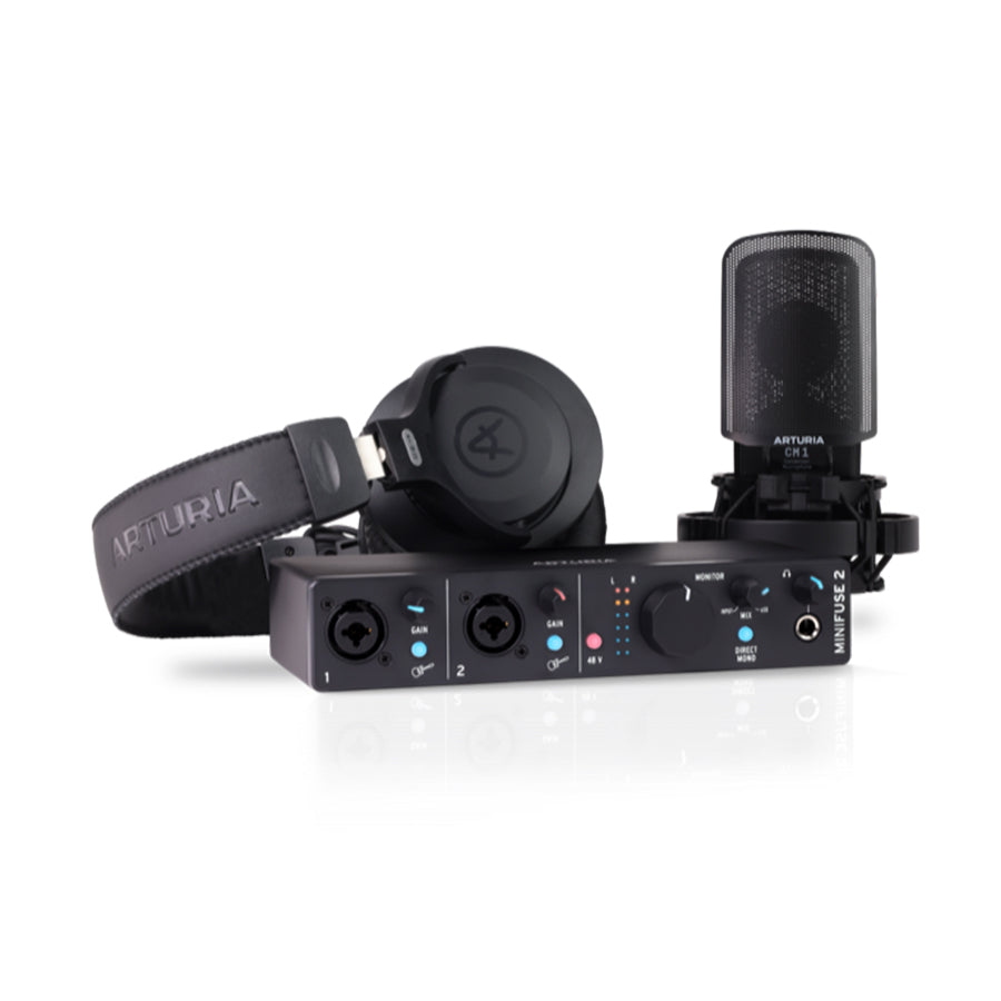 Black audio interface with two combo input jacks, headphones, and a microphone with shock mount on a white background.