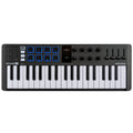 Black MIDI controller with 37 keys, 8 pads with blue backlight, 9 knobs, 4 faders, buttons, and a small display in the center.