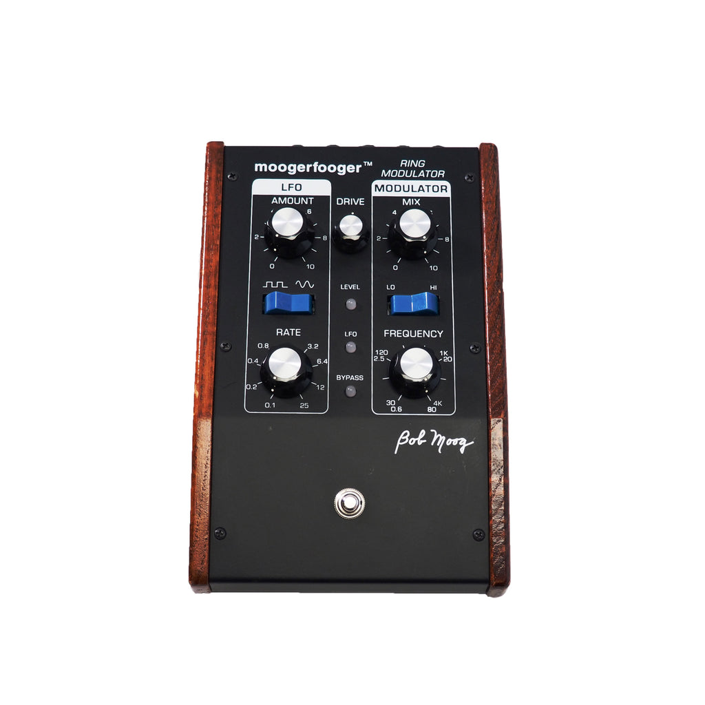 Black and wooden guitar effects pedal with knobs, switches, and 'moogerfooger ring modulator' text on top panel.