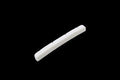 A white slotted bone nut with six string slots for a precision bass style instrument.