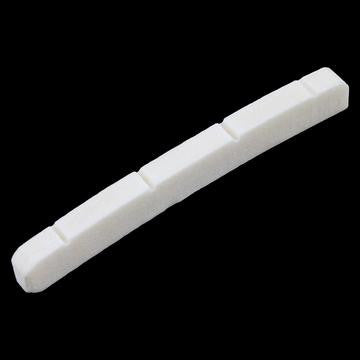 White slotted nut piece for a stringed instrument on a black background.