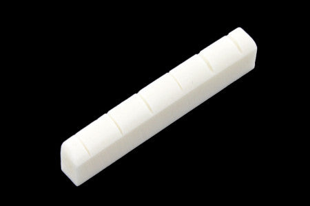 White slotted bone-style guitar nut with six evenly spaced slots shown against black background.