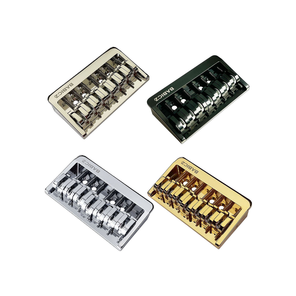 Four Babicz 7-string fixed hardtail guitar bridges in silver, black, chrome, and gold finishes.