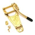 Gold-colored vibrato tailpiece with arm, spring, and screws on a white background.