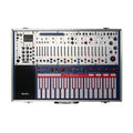 Top view of a Buchla Electronic Music Box with sliders, knobs, touch keys, and multiple jacks in a metal case.