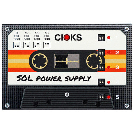 Black rectangular pedal power supply unit with cassette-style design and multiple dip switches labeled 1 to 5.