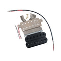 Electric guitar humbucker pickup components including coils, baseplate, screws, and wires.