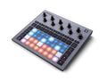 Gray music production controller with illuminated pads, rotary knobs, and buttons on the top surface.