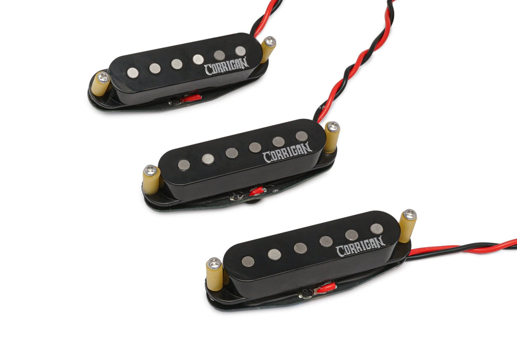 Three black single-coil guitar pickups with wire leads and Corrigan logo on each pickup cover.