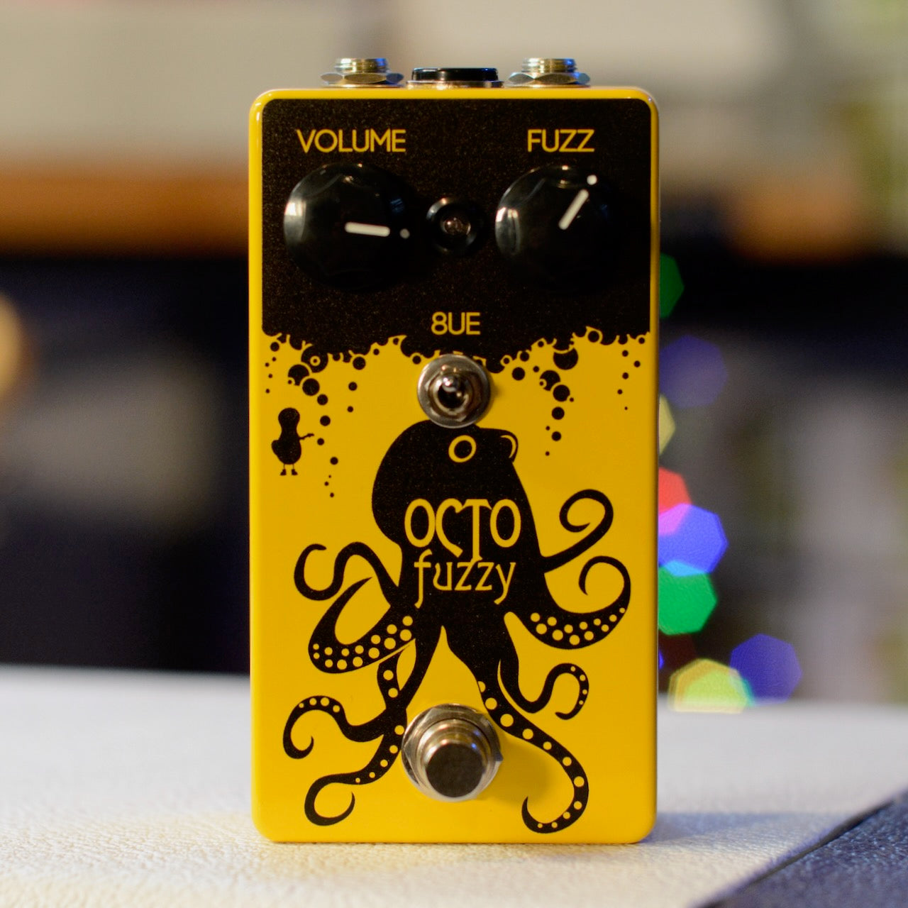 Yellow and black guitar effects pedal with octopus graphic and controls labeled Volume and Fuzz.