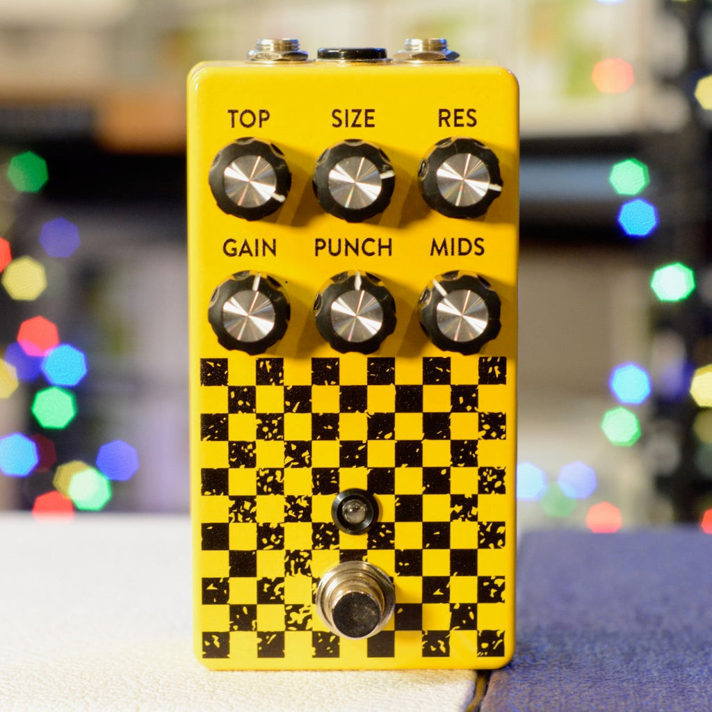 Yellow guitar effects pedal with six knobs, a footswitch, and black checkerboard pattern.