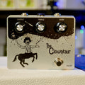 Silver guitar pedal with black clown centaur graphic and three knobs labeled Output, Treble, Gain.