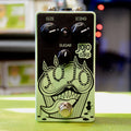 Light green guitar effects pedal with three black knobs and a footswitch, labeled Jojo Cake with cupcake illustration.