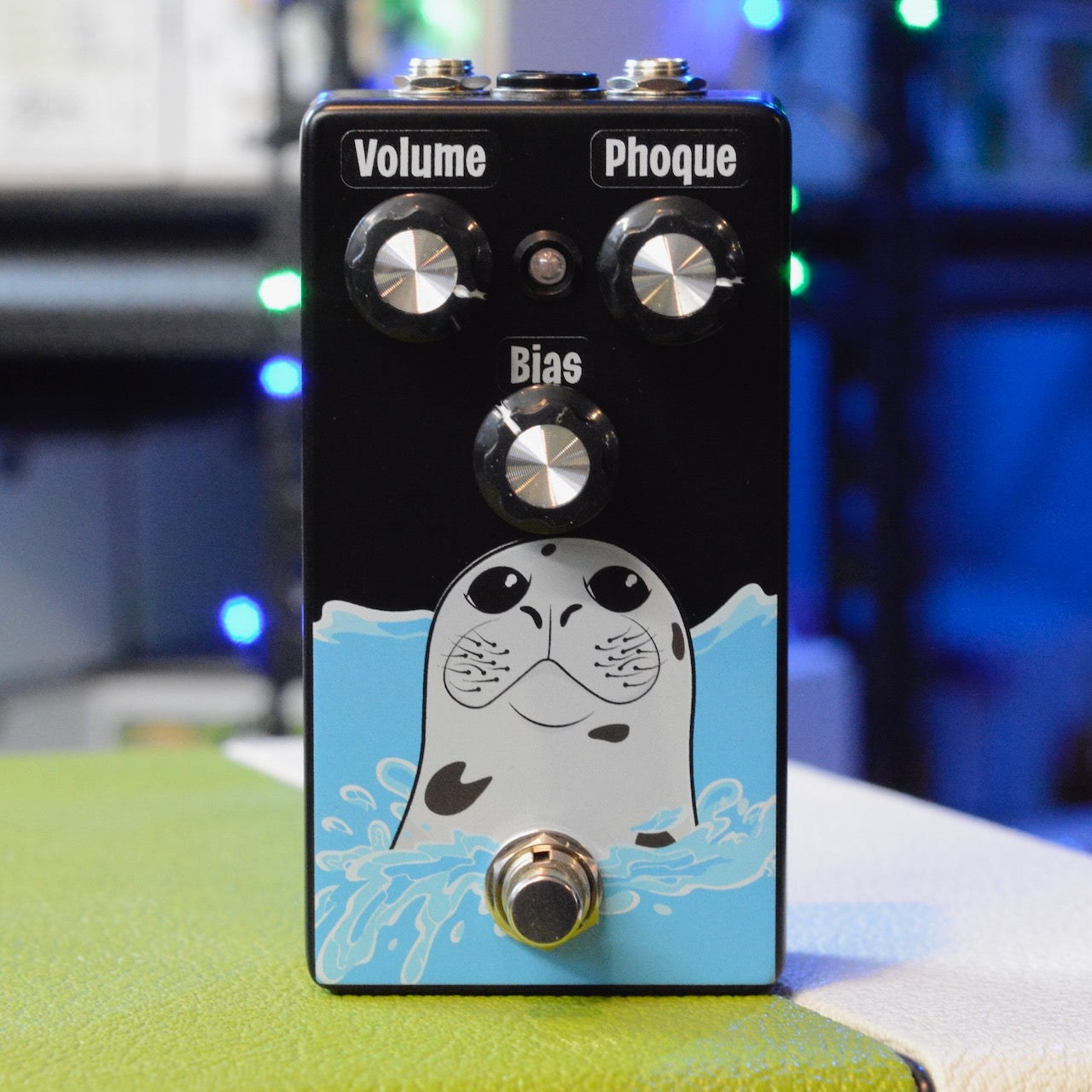 Black guitar effects pedal with three silver knobs, footswitch, and seal graphic on front panel.